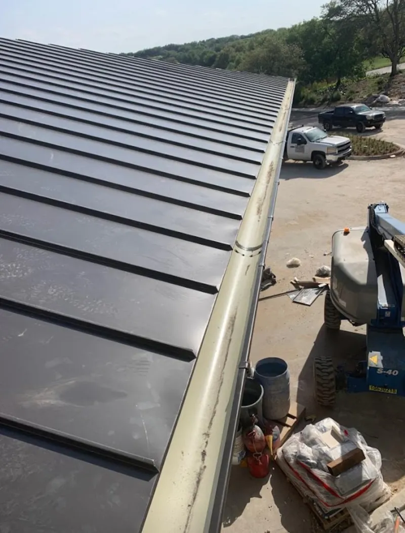 Standing seam panel and gutter detail on a metal roofing jobsite in Oakland